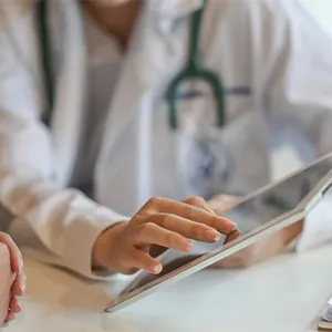 Doctor reading information from a tablet