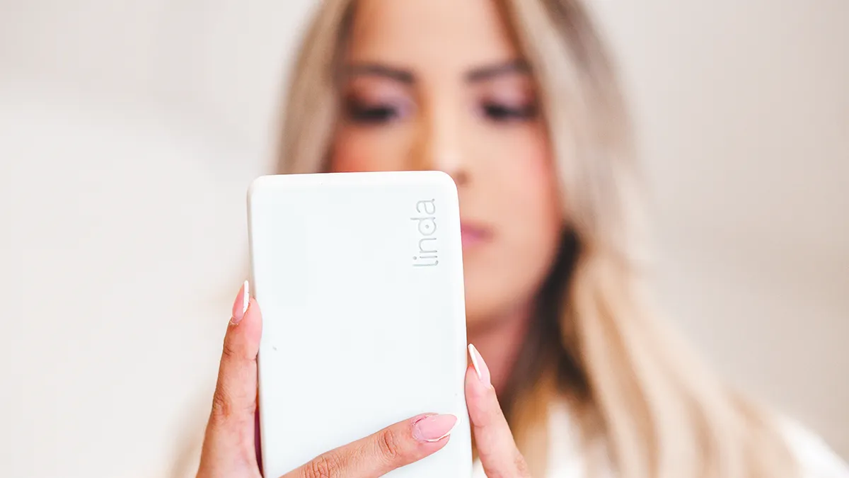 A woman looking at her LINDA device