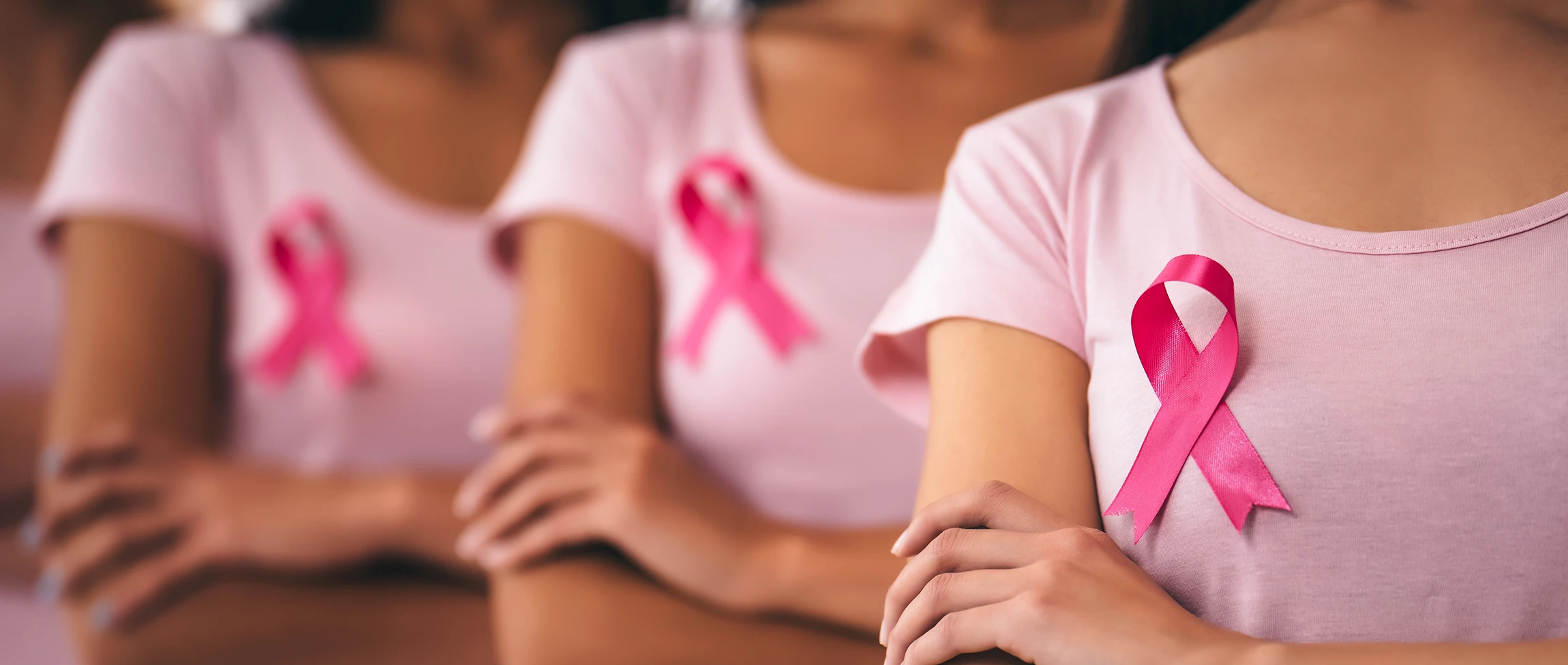 Women wearing pink tshirts and a cancer ribbon
